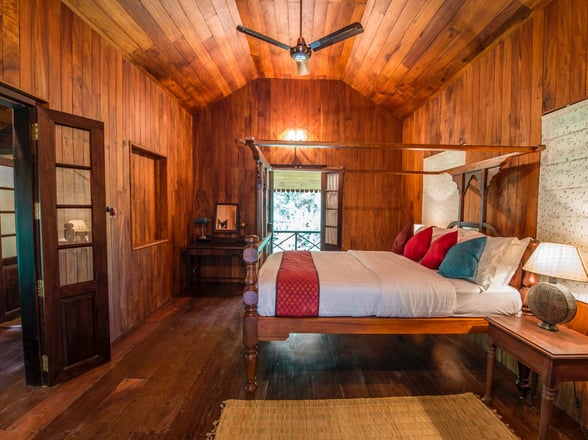 Inside view of Mackenzie bed room with wood panelled walls and open balcony doors at the back of the room